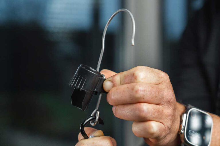 Befestigen: Befestige den Gegenstand (z. B. eine Lampe) an der Öse des Hakenmoduls.